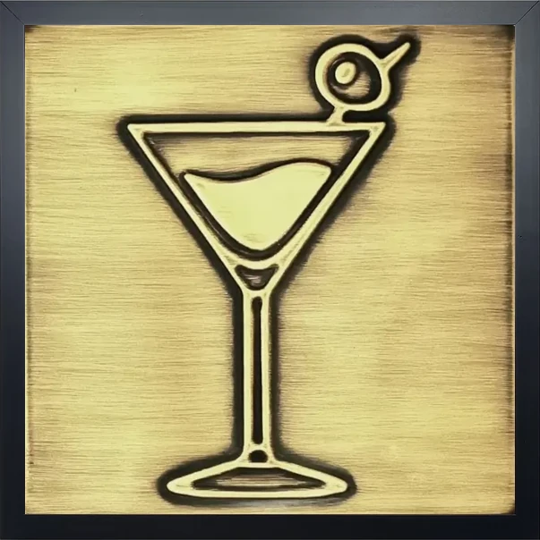 A glass of martini on brass tile in wooden frame