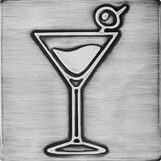 A glass of martini with olive on stainless steel tile