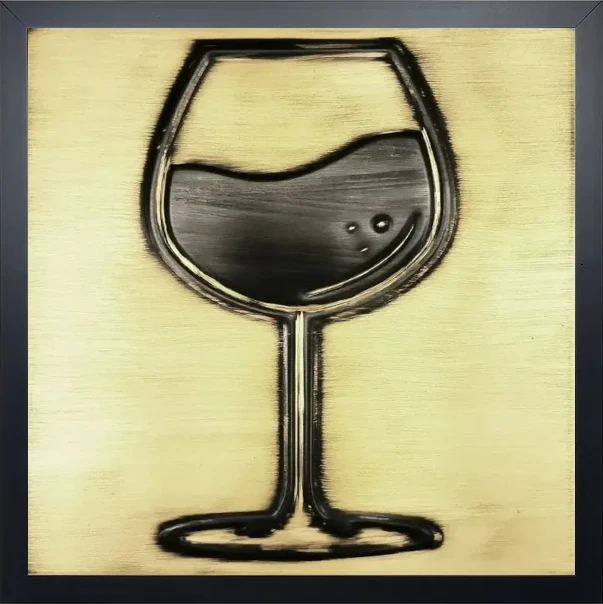 A glass of wine on brass tile in wooden frame