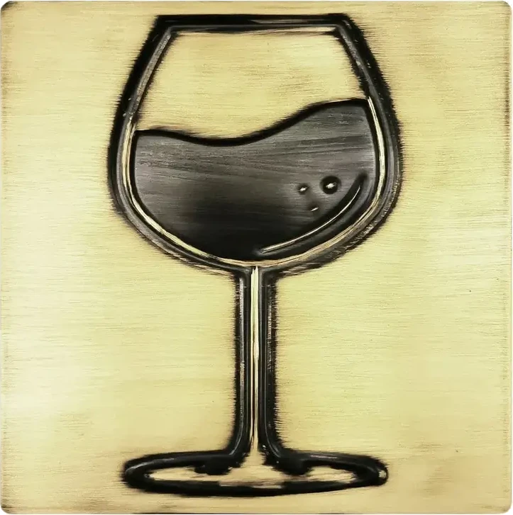 A glass of wine on brass tile